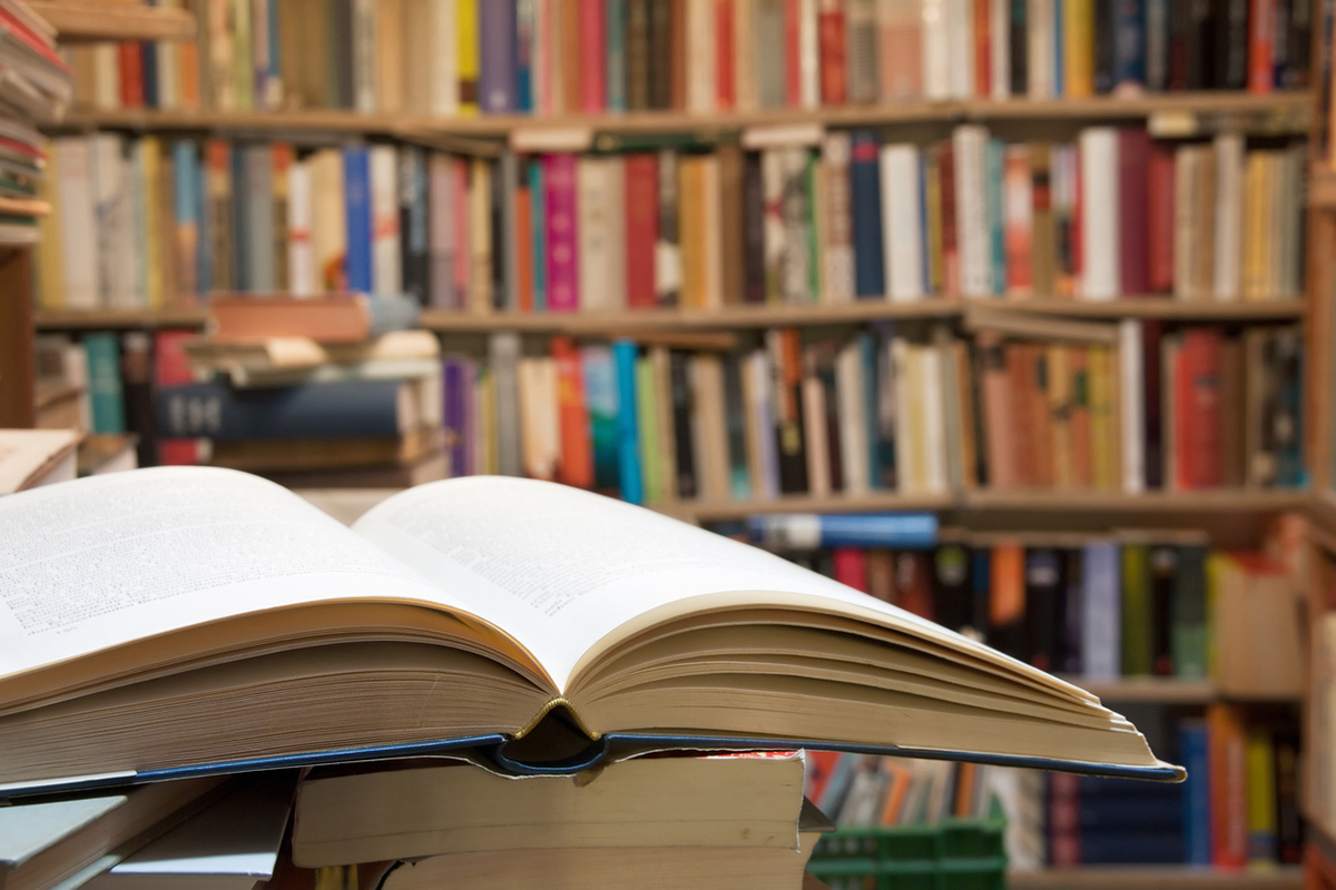 Open book in fronts of shelves of books