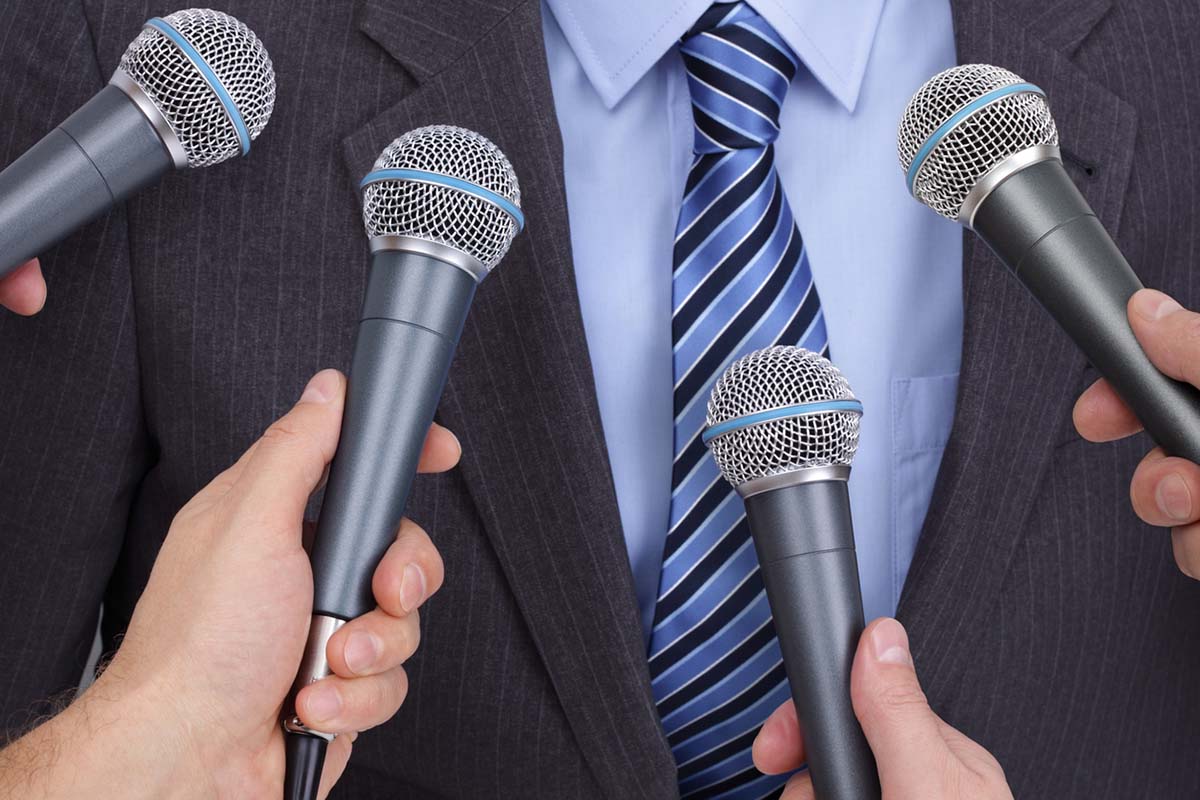 Microphones in front of businessman who is the messenger for his company